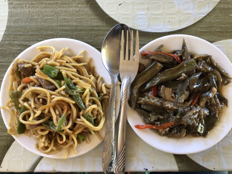 dos platos, uno de noodles y otro de verduras a la brasa. Gastronomía típica en Filininas