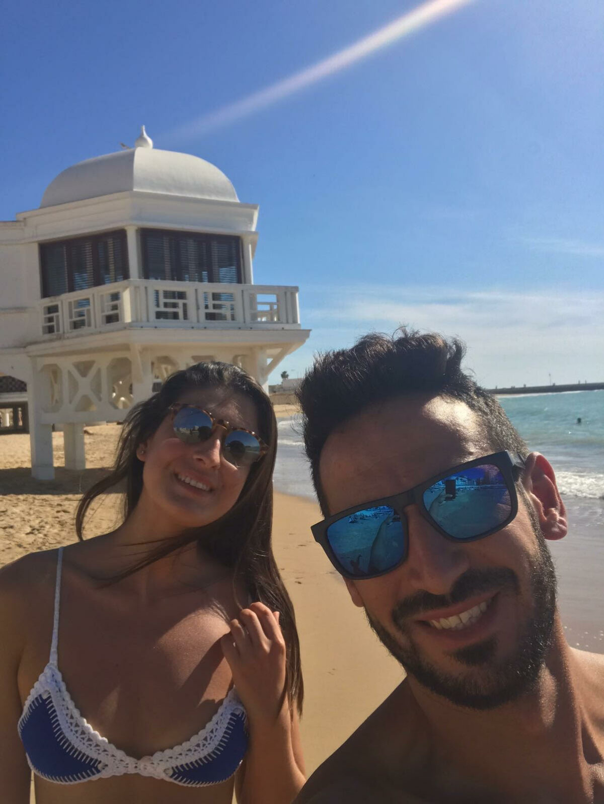 Pareja delante del edificio del balneario de la playa de la caleta