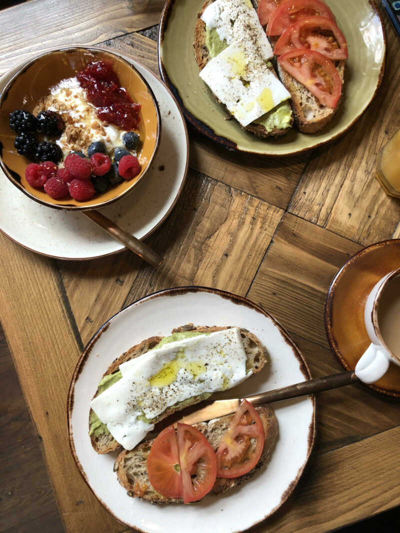 dos tostadas con tomate queso y aguacate y un bowl de fruta. Desayuno en Sevilla